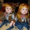 Two red headed porcelain dolls in matching country outfits.