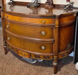 A wooden dresser with a rounded front.