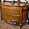 A wooden dresser with a rounded front.