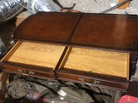 A desk with the drawers pulled out.