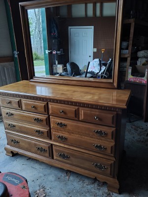 A wooden dresser with a mirror.