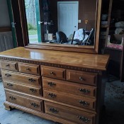 A wooden dresser with a mirror.