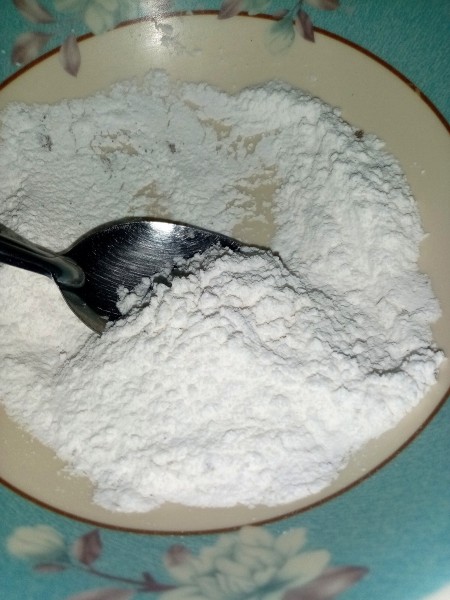 A bowl containing a flour coating for the eggs.