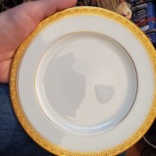 A china plate with a gold rim.