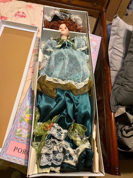 A porcelain doll in a box.