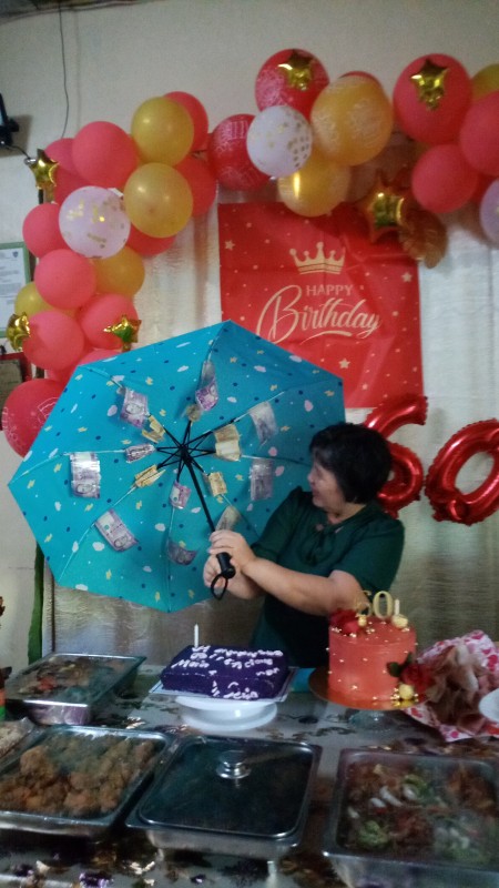 A woman opening the umbrella to discover the money inside.