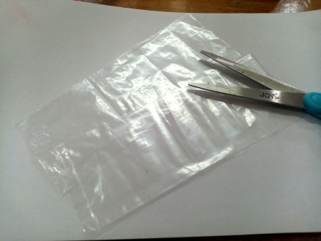 Cutting a plastic bag in half.