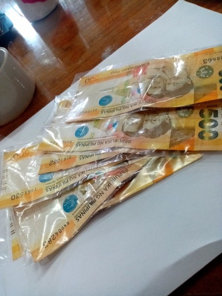 Placing money inside the plastic.