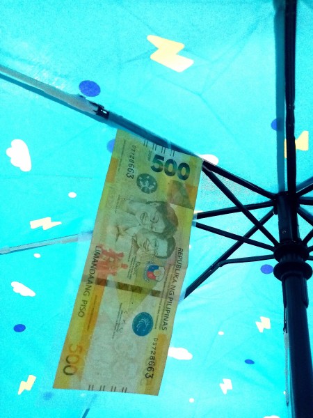 Attaching money to the underside of the umbrella.