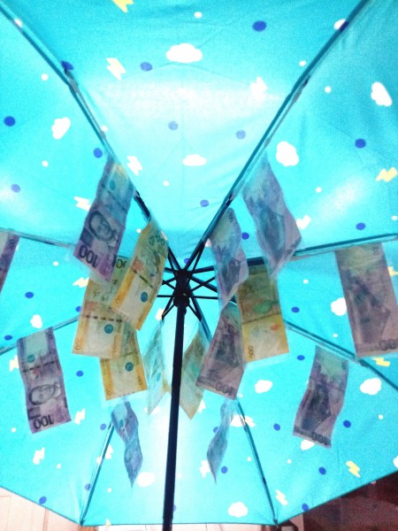Attaching money to the underside of the umbrella.