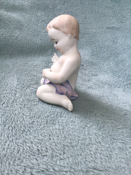 Side view of the baby figurine.