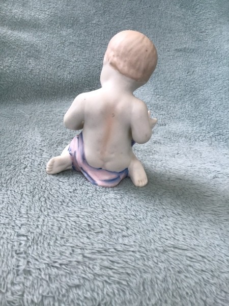 Back view of the baby figurine.
