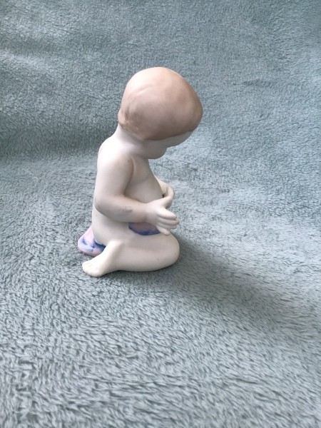 Side view of the baby figurine.