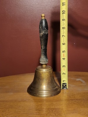 A brass hand bell used in school.