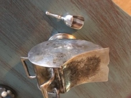 A small metal container with a tiny scoop.