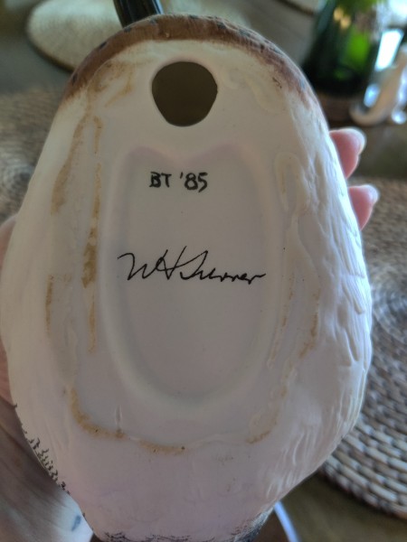 A signature on the underside of a duck figurine.