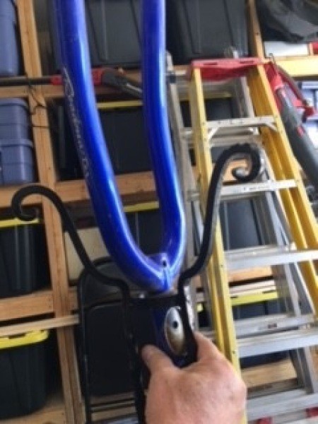 Attaching a bike wheel fork to a metal plant stand.