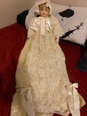 A doll wearing a long white gown.