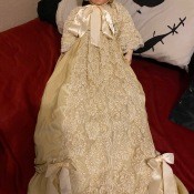 A doll wearing a long white gown.