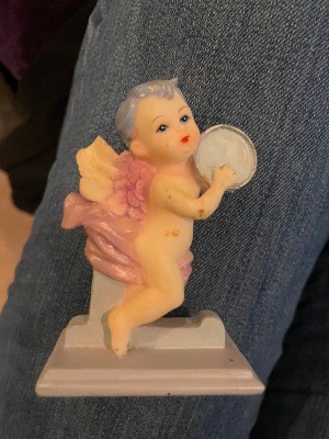 Cherub sitting on the letter "L".