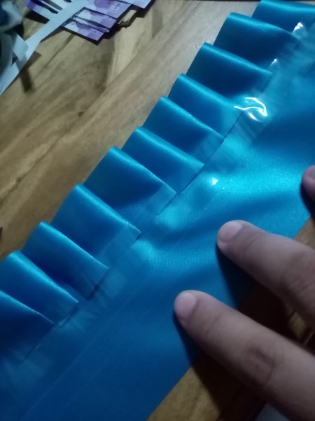 Gathering the ribbon and attaching it to another piece.