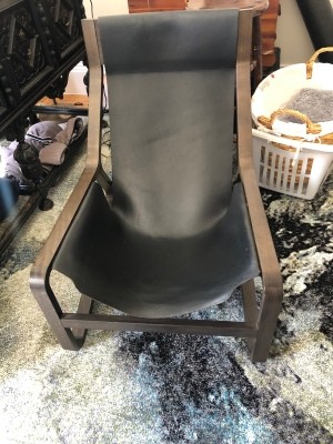 A leather chair with a wooden frame.