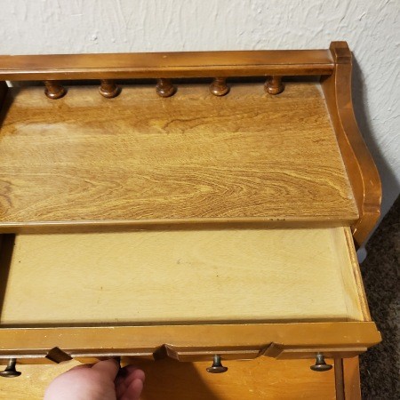 An open drawer on a piece of Bassett furniture.
