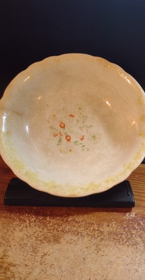 A bowl with a worn floral pattern.