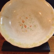 A bowl with a worn floral pattern.