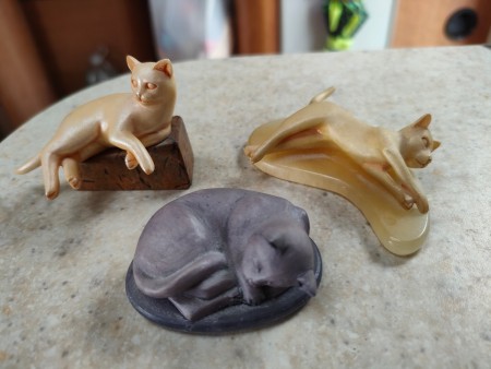 Three cat figurines.