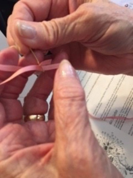 Sewing the ribbon into a pattern.