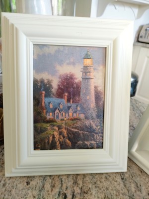 A small painting of a lighthouse.