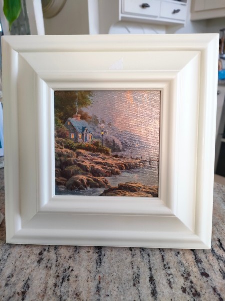 A small painting of a rocky seashore.