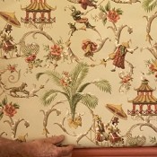 A decorative piece of wallpaper with figures, palm trees and decorative structures.
