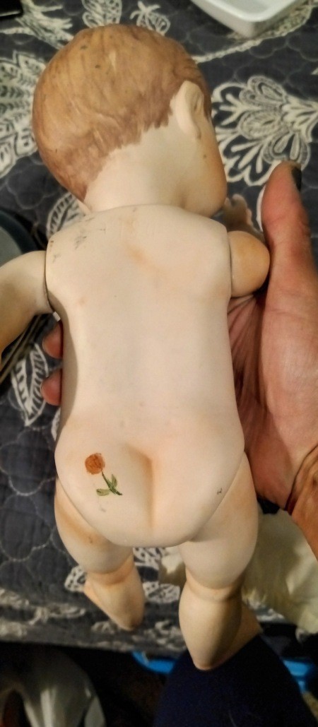 A rose marking on the backside of a doll.
