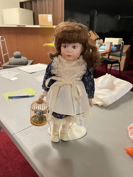 A porcelain doll on a stand.