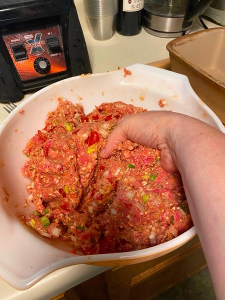 Mixing the meatloaf with hands.