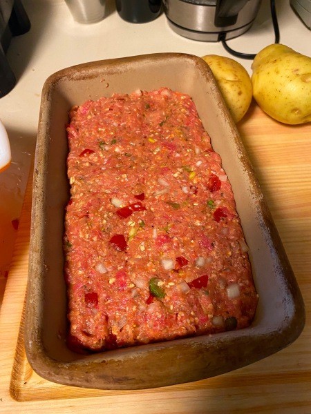 The meatloaf in a loaf pan.