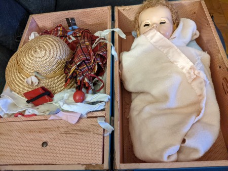 The doll in a chest with clothes.