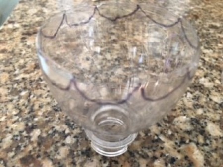 Adding scallops to the edge of the cut bottle.