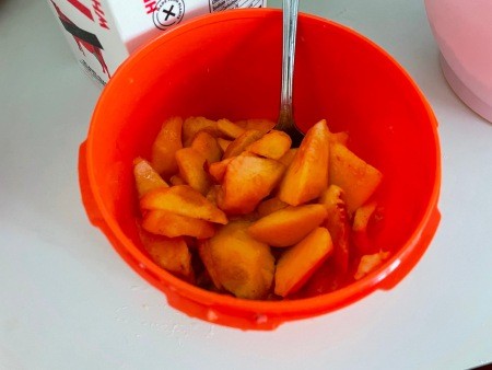 A bowl of sliced peaches.