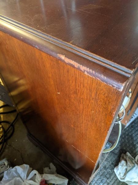 The side of a phonograph radio console.