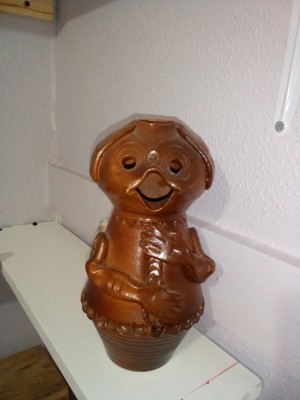A small brown figurine with an open mouth.
