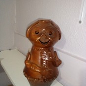 A small brown figurine with an open mouth.