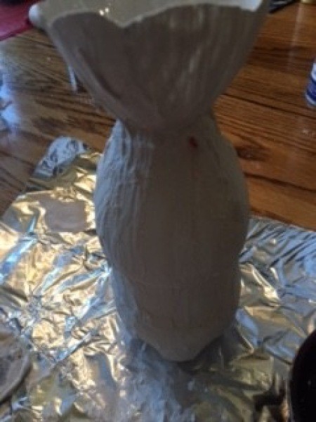 Covering the plastic vase with plaster of Paris.