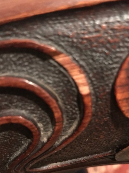 A close up of the carved wooden chair.