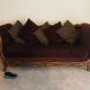A wooden upholstered sleigh couch.