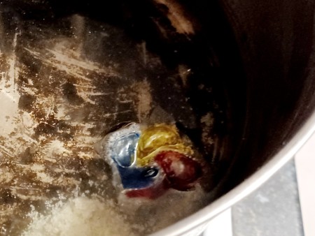 Putting the dishwasher pods in the bottom of the pan.