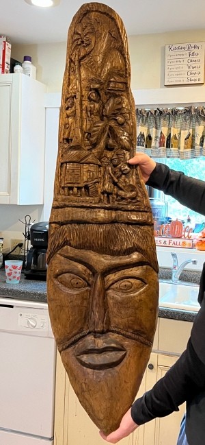 A tall carved wooden sculpture of a face.