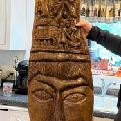 A tall carved wooden sculpture of a face.